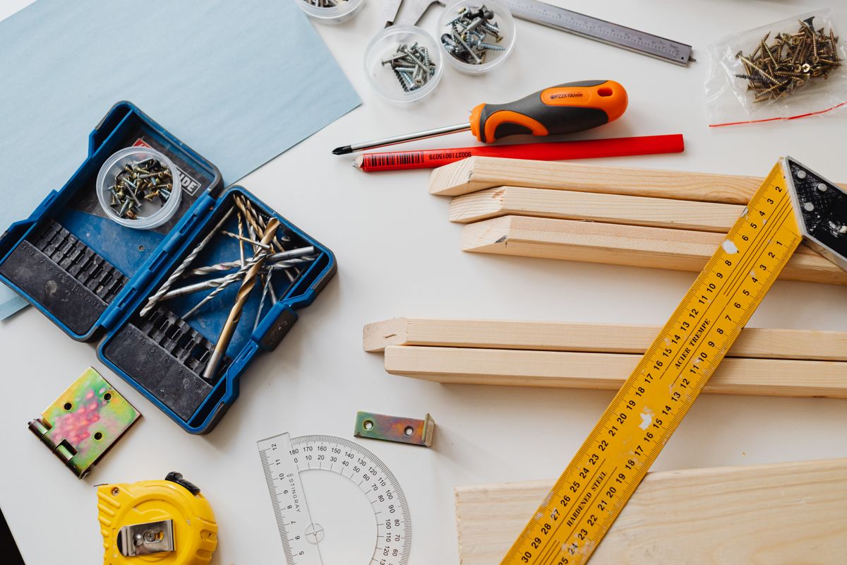 Simple hand tools, screws and softwood battens laid out on a workbench